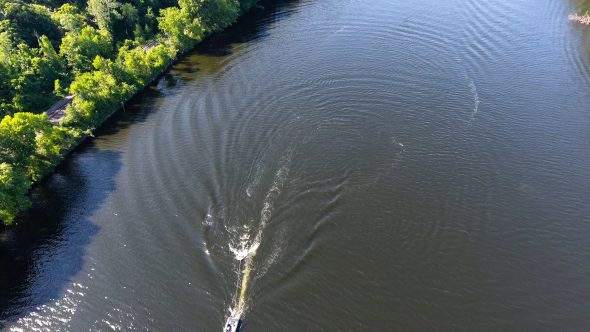 Aerial Drone Footage of a Boat Pulling a Tube on A River Royalty Free Stock Drone Video Footage