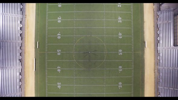 Overhead aerial, man stands on football field at night Royalty Free Stock Drone Video Footage