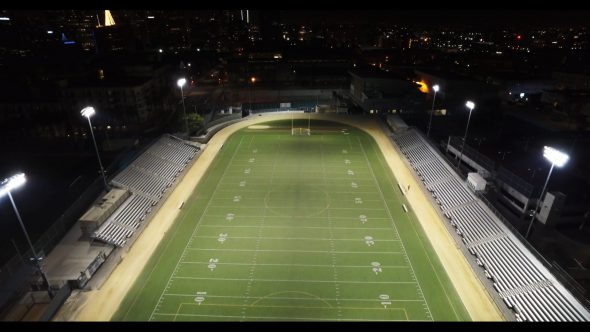 Tilt up aerial, football stadium at night in city Royalty Free Stock Drone Video Footage